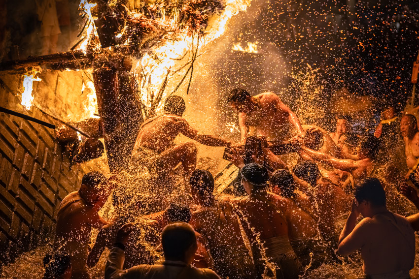Photograph depicting men leaping into the river at the Abare Festival in Japan as torches blaze. This is a traditional celebration that has been passed down for over three centuries in the Noto region of Japan. Taken by Megumi Murakami of Japan and the winner of the Travel category in the Open Competition of the Sony World Photography Awards 2026