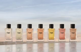 Fendi fragrances lined up in a row in front of a sunset background