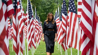 TOPSHOT - US First Lady Melania Trump walks through 453 American flags, each representing a child in foster care in Cabell County, West Virginia, many due to the opioid epidemic, at Ritter Park in Huntington, West Virginia, July 8, 2019. (Photo by SAUL LOEB / AFP) (