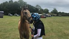 A young rider kissing her pony after a competition