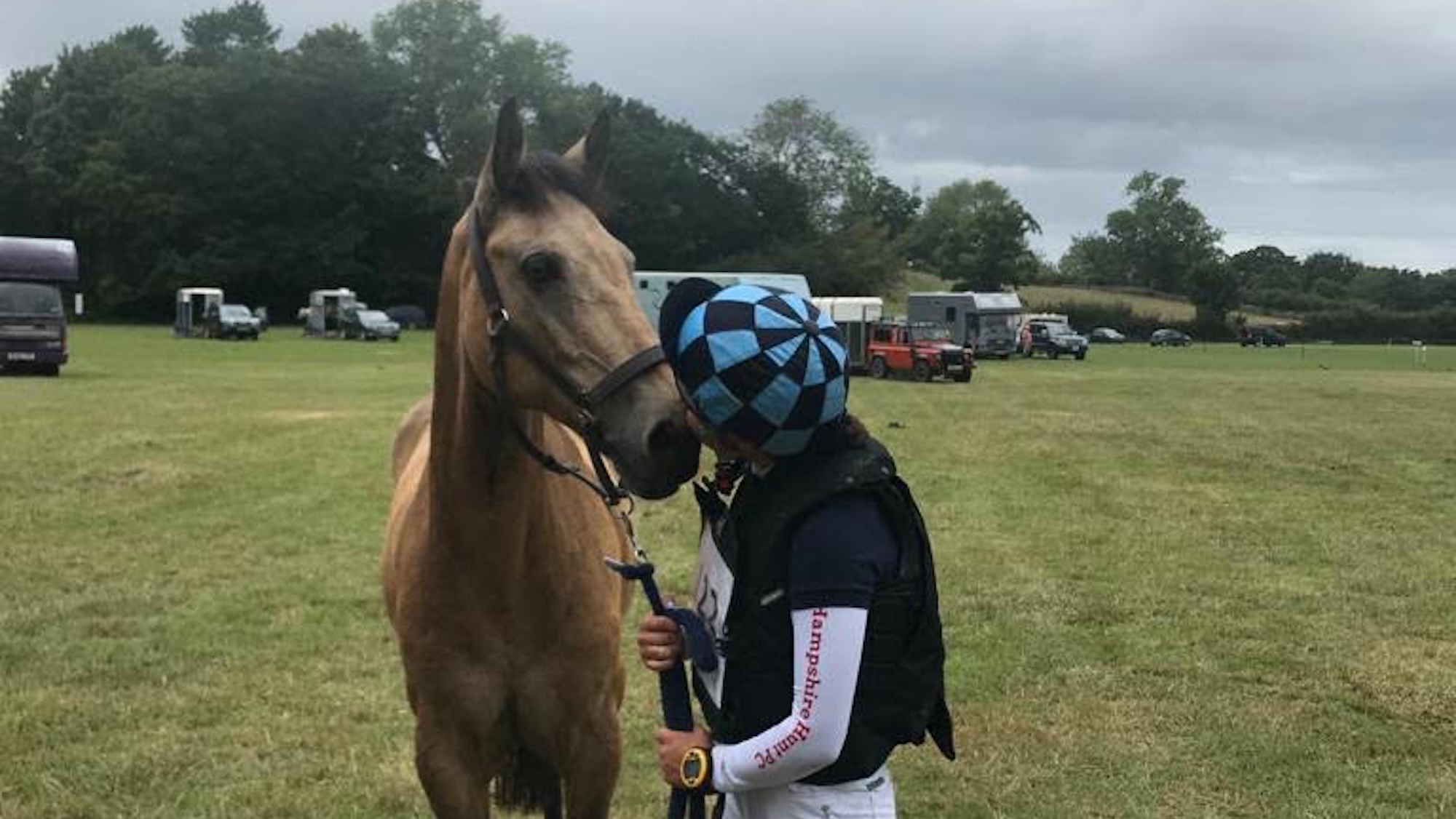 A young rider kissing her pony after a competition