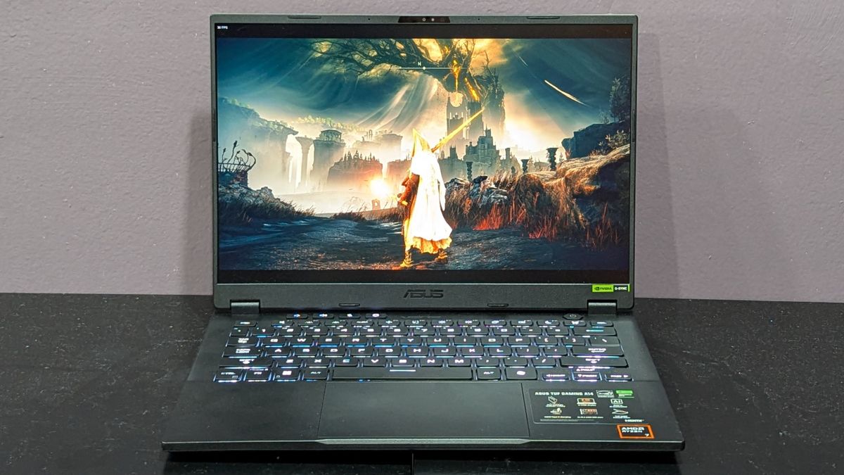 A front-facing view of an open and powered on laptop on top of a black surface.
