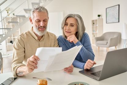 Couple comparing home insurance quotes sitting in front of a laptop