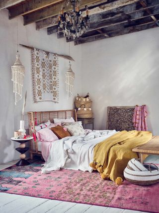 Pink bedroom with wooden beams and boho style