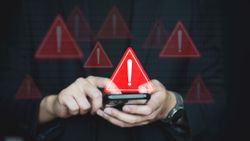 A person holding a phone looking at a text with warning signs