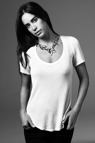 Model wearing necklace and white top