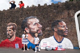 Fans by a new mural in Nuneaton by artist Nathan Parker, depicting Gareth Southgate, Harry Kane and Raheem Sterling
