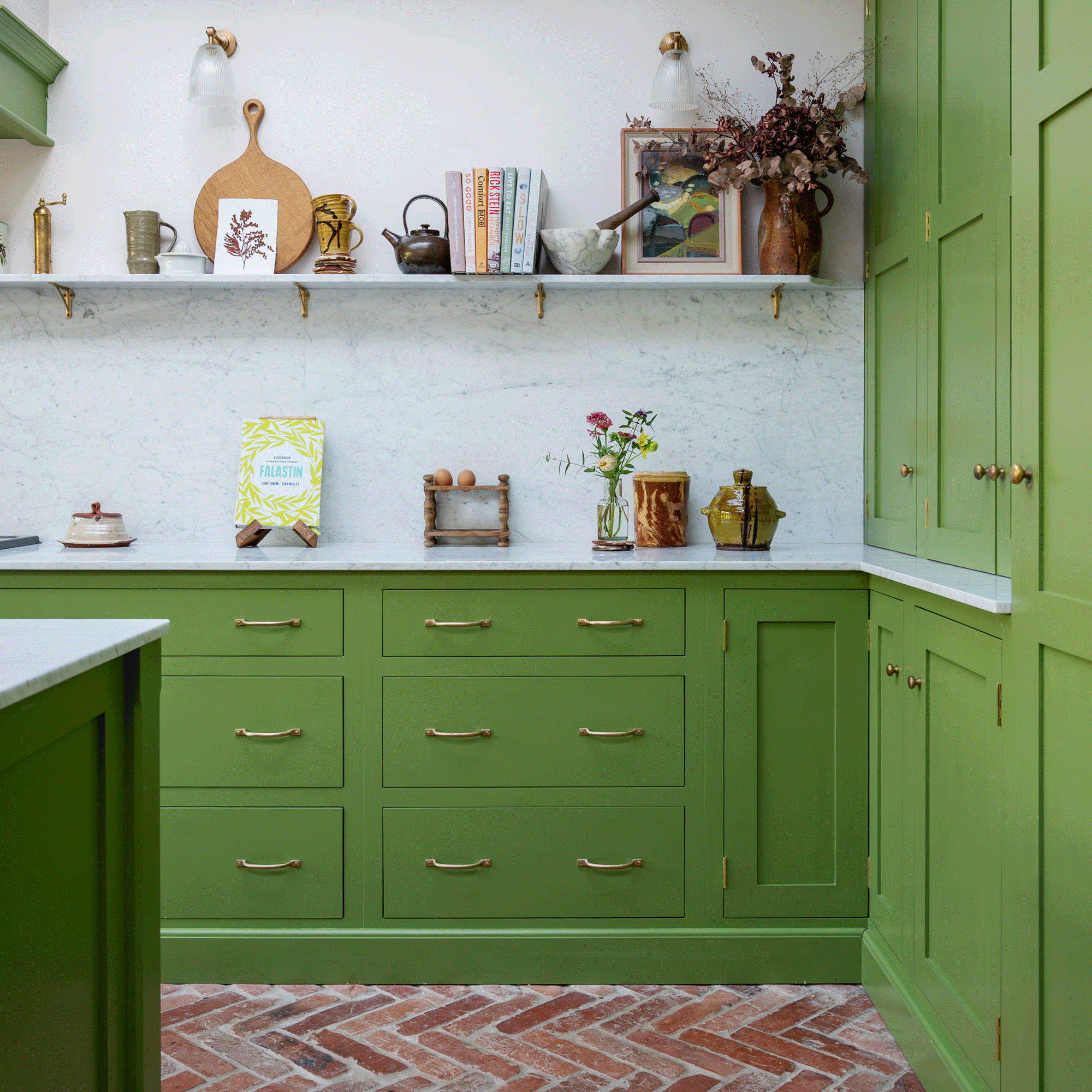 a green shaker kitchen with open shelving and herringbone flooring