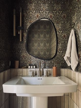 Small powder room with wallpaper and mirror