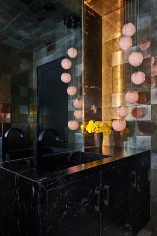 A small bathroom with pendant light next to the mirror