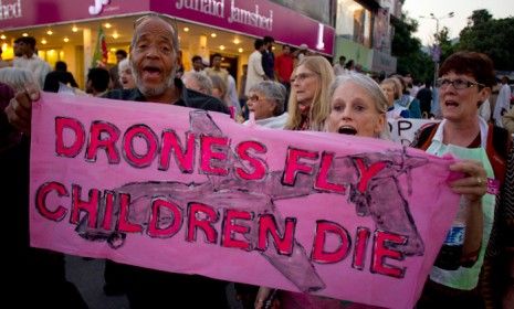 American citizens hold a banner that reads, &amp;quot;Drones fly children die&amp;quot;, during an anti-war rally in Pakistan on Oct. 5, 2012.