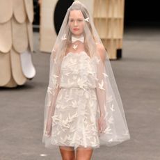 Model wears a mini wedding dress at the Chanel Haute Couture Spring Summer 2023 runway show