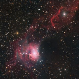 a swath of pink gas stretches across a span of stars in space.