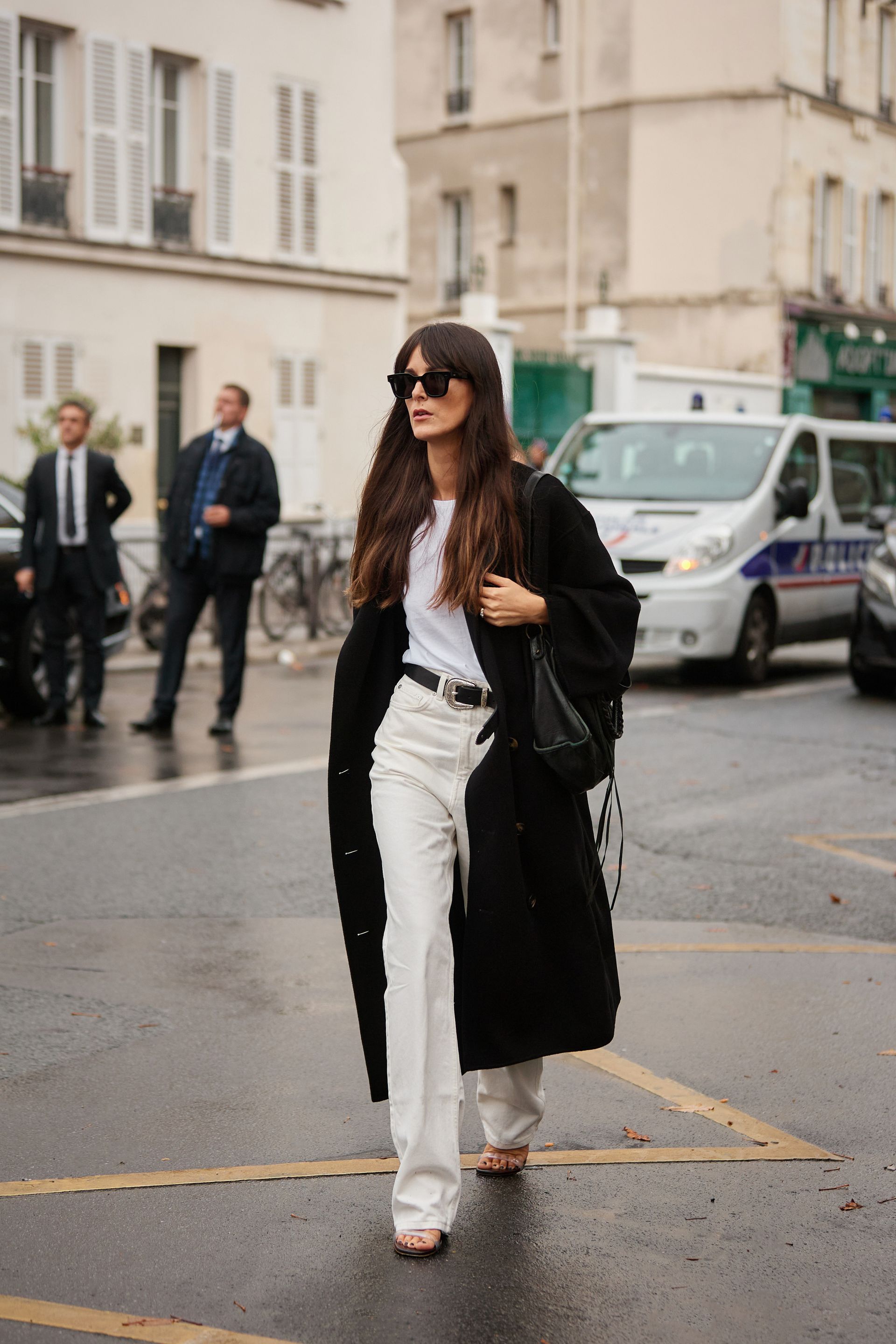 a woman wears high-waisted jeans with a white tee, jacket, and heels.