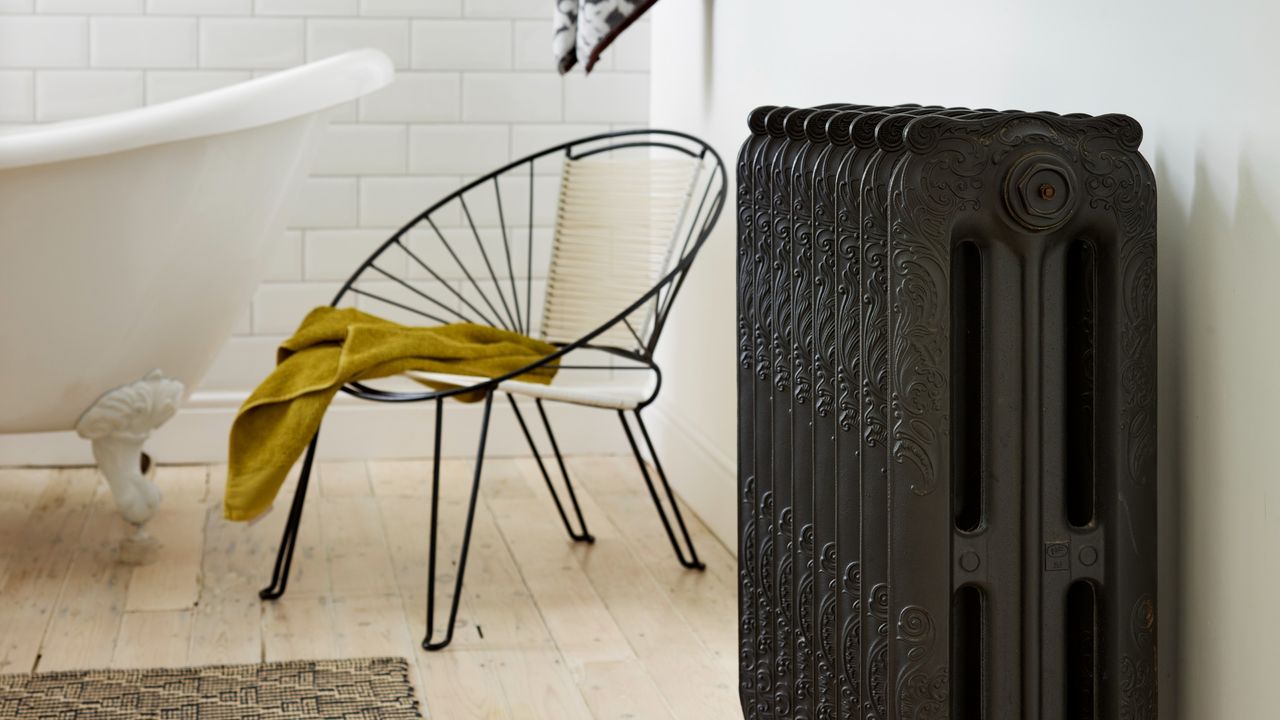 A bathroom with a bathtub and a black antique radiator