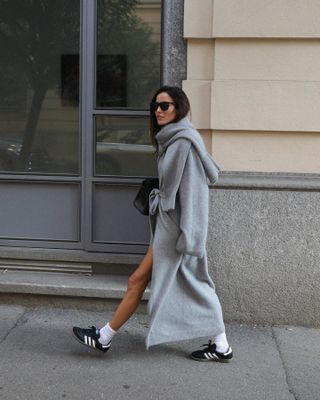  @ariviere wearing a gray coat and black Adidas Sambas.