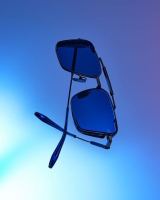Close up image of the 'Hera' sunglasses suspended in the air, blue faded back ground