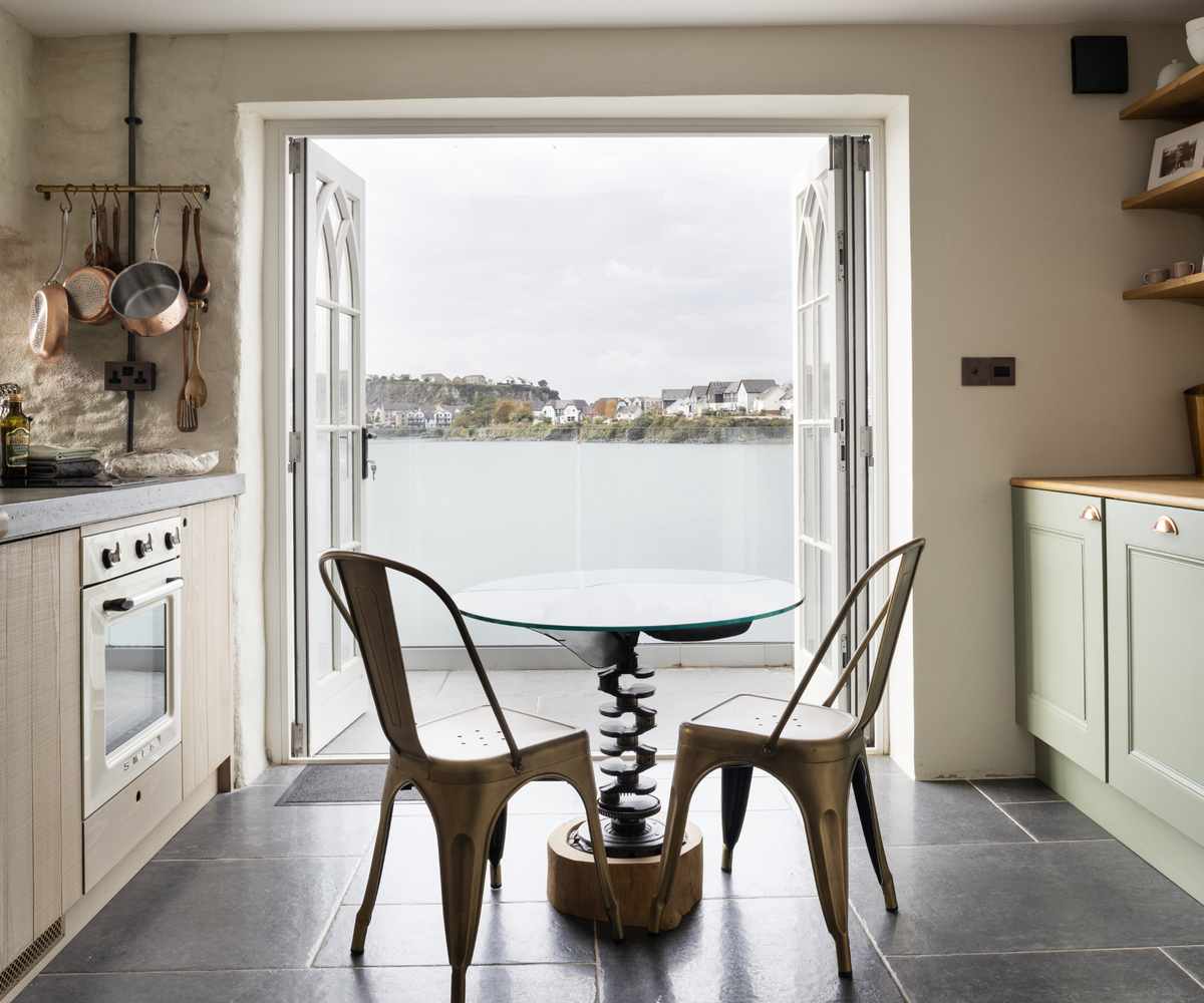 kitchen with a table and chairs overlooking lake view balcony