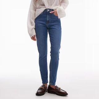 A close up of a models bottom half wearing Jamie Topshop jeans and loafers