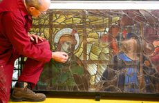 Sam Kelly, head of glass conservation at Salisbury Cathedral, takes a look at Burne-Jones's large stained glass figures in the workshop. Credit: Finnbarr Webster