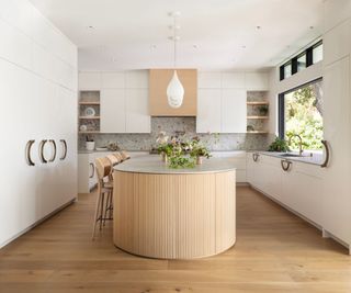 kitchen with wooden floor and reeded wood island and white cabinets