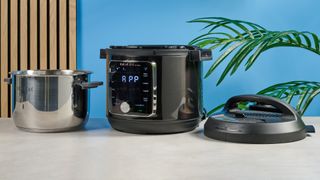 a black smart home enabled wi-Fi instant pot with a touchscreen and a 6QT inner pot is photographed against a blue background