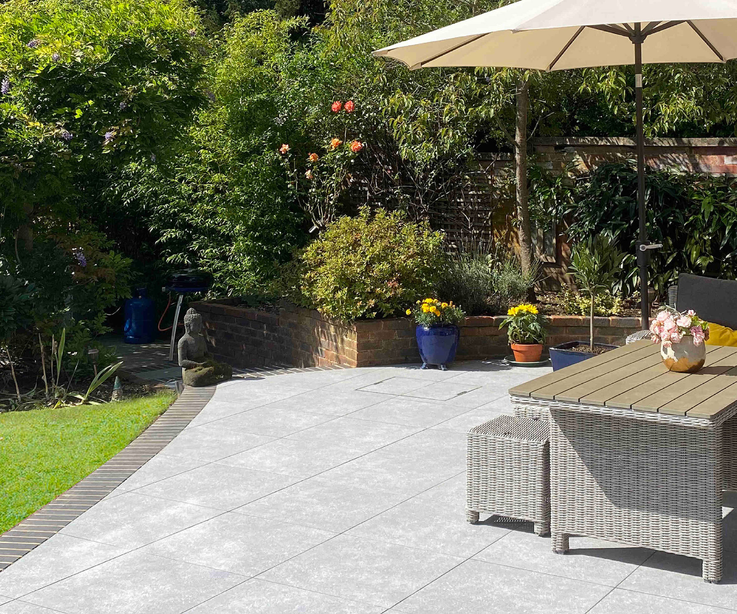 A light porcelain patio edged with grey brick