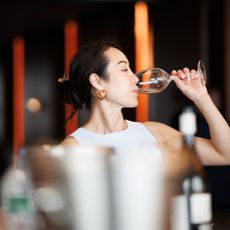 woman drinks from glass of wine