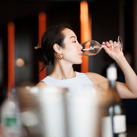 woman drinks from glass of wine