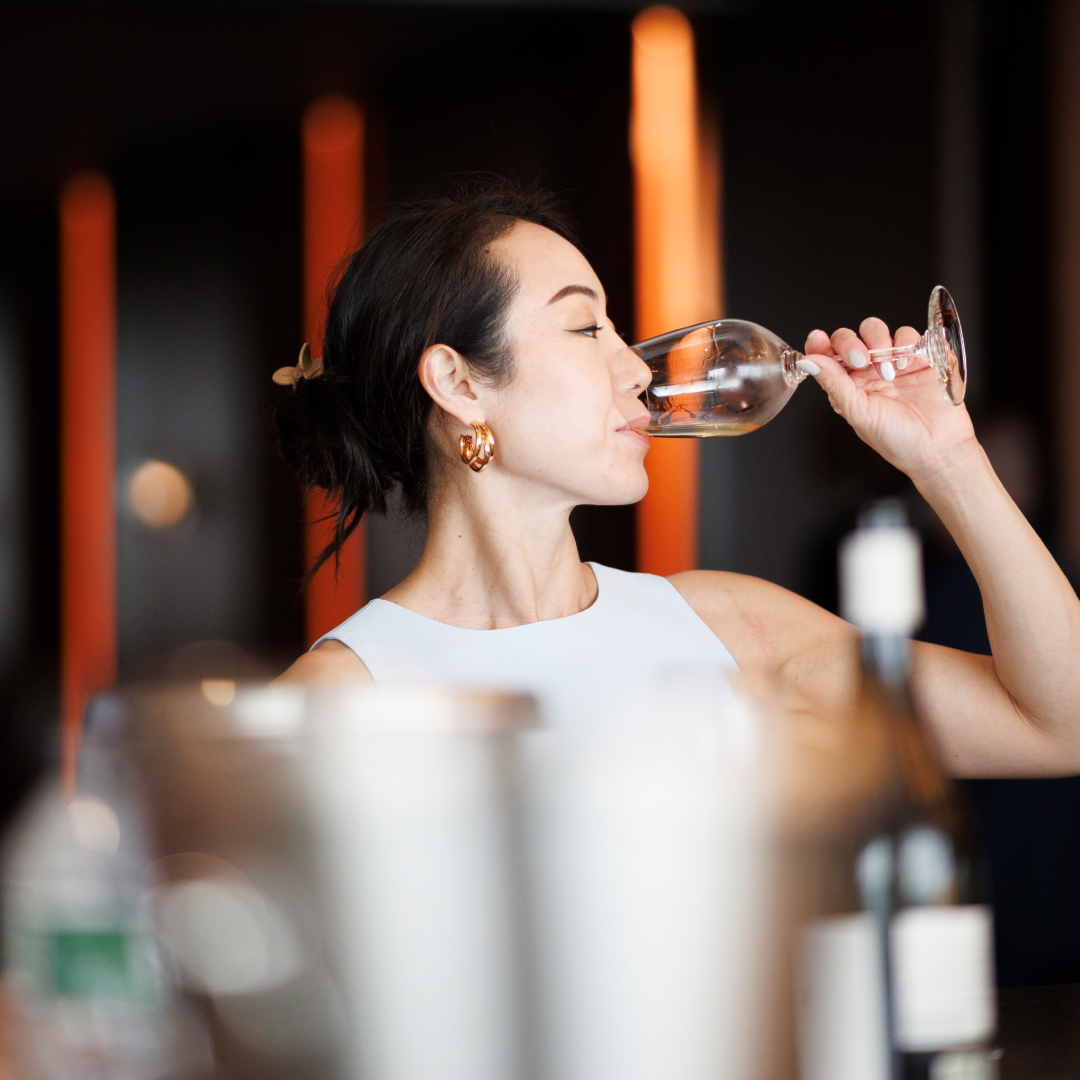 woman drinks from glass of wine