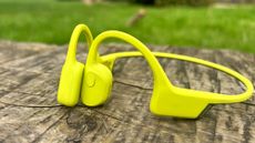 Suunto Sonic bone conduction headphones in lime on a wooden table