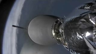 The first stage of a SpaceX Falcon 9 rocket (background left) falls away from its second stage in this view from a camera on the second stage taken on Dec. 5, 2019 during the CRS-19 Dragon cargo launch.