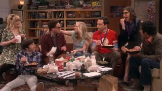 A screenshot still of the cast sitting on and around the couch eating Chinese food on The Big Bang Theory finale.