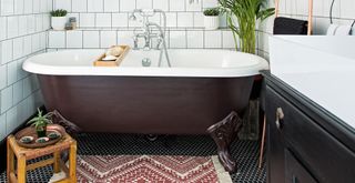 white bathroom with a brown painted freestanding bath with a bath mat to suggest how to style a bathroom for Christmas