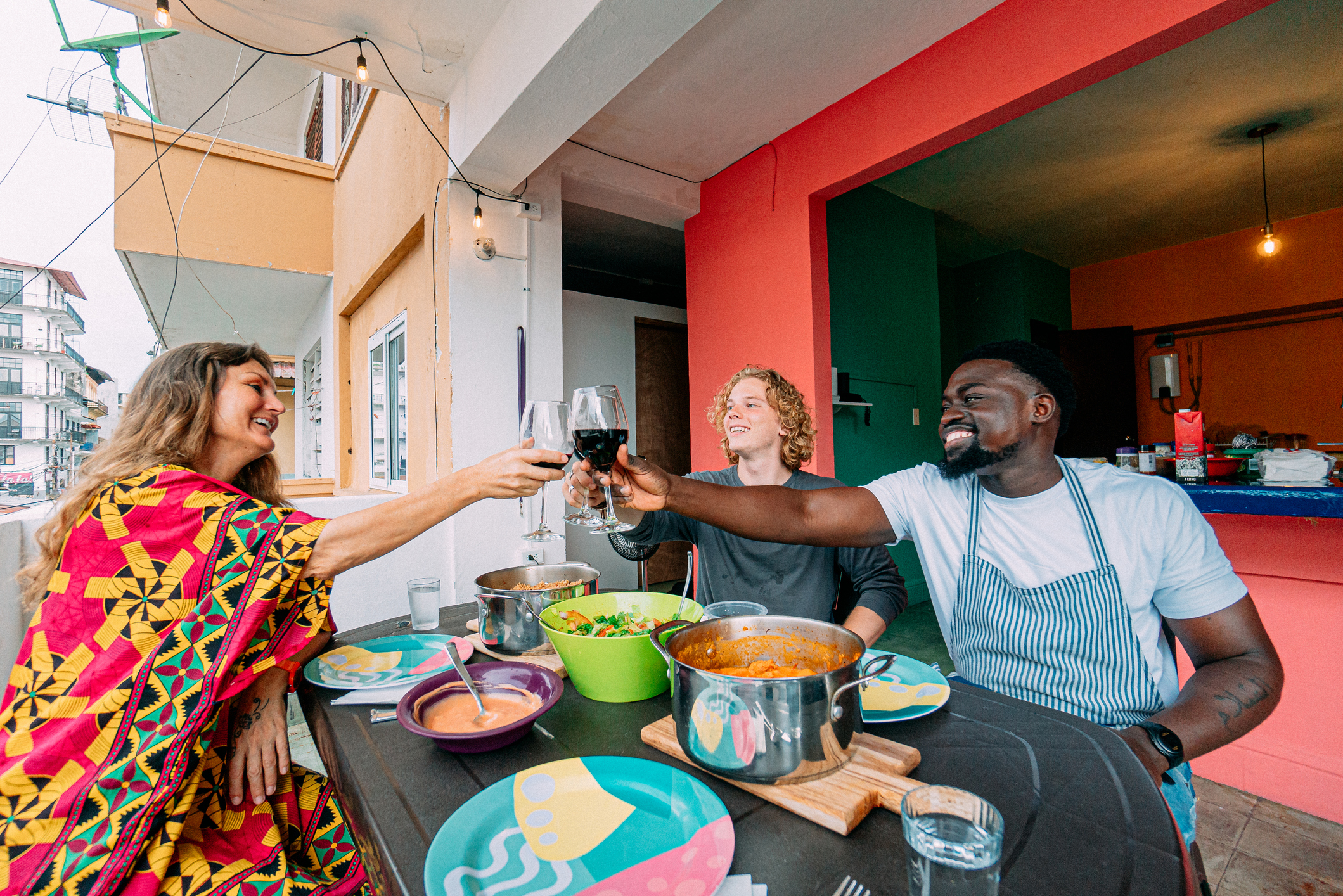 &quot;Cheers!&quot; Multi-Racial Group Share a Celebratory Toast Before a Delicious Dinner on a Balcony at a Bed &amp;amp; Breakfast in Panama City, Panama