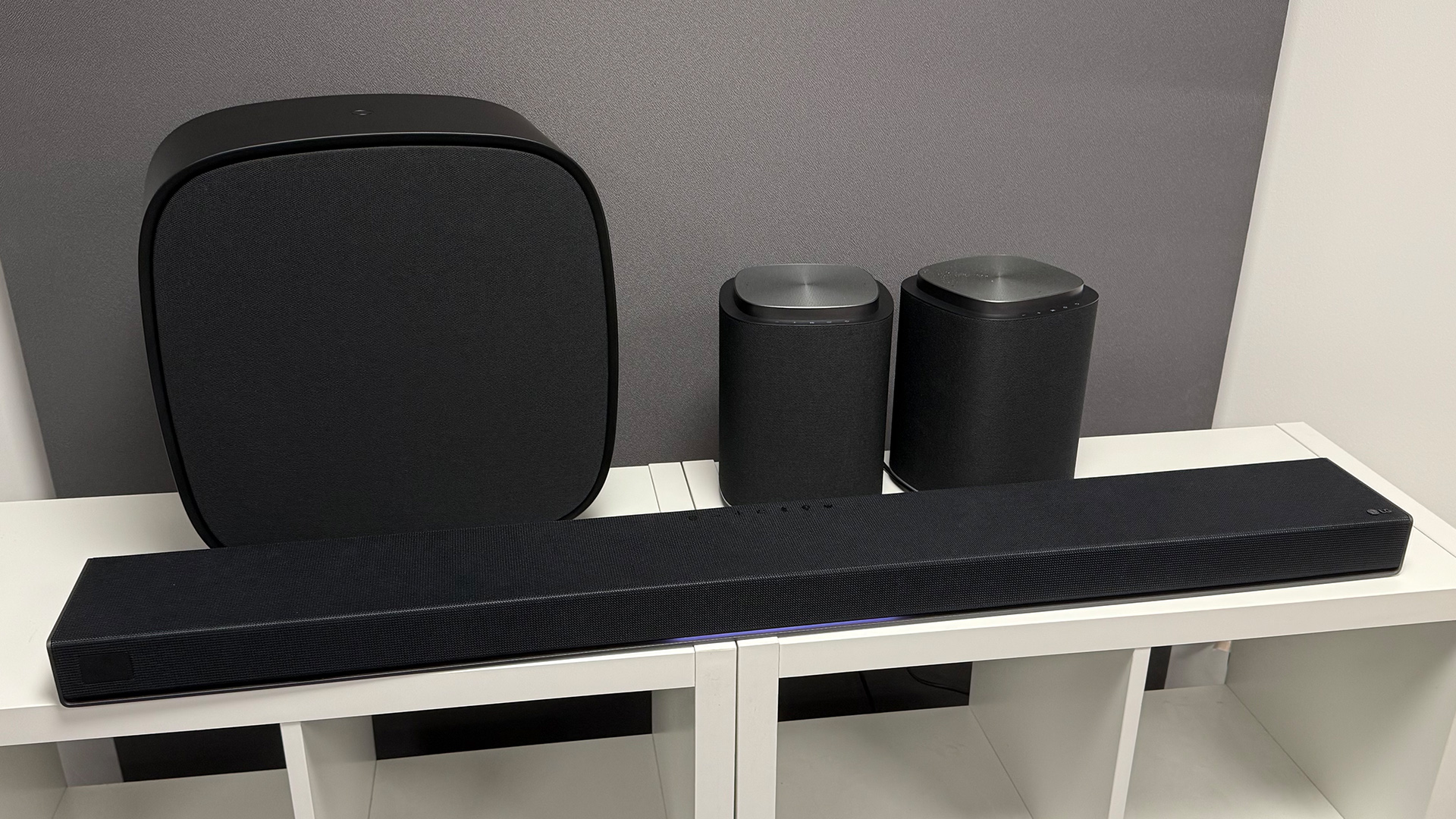 LG Sound Suite system soundbar system on white wooden shelving unit