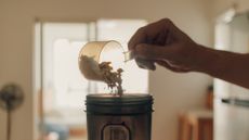 When is the best time to drink protein shakes? Image shows person loading protein powder into a shaker