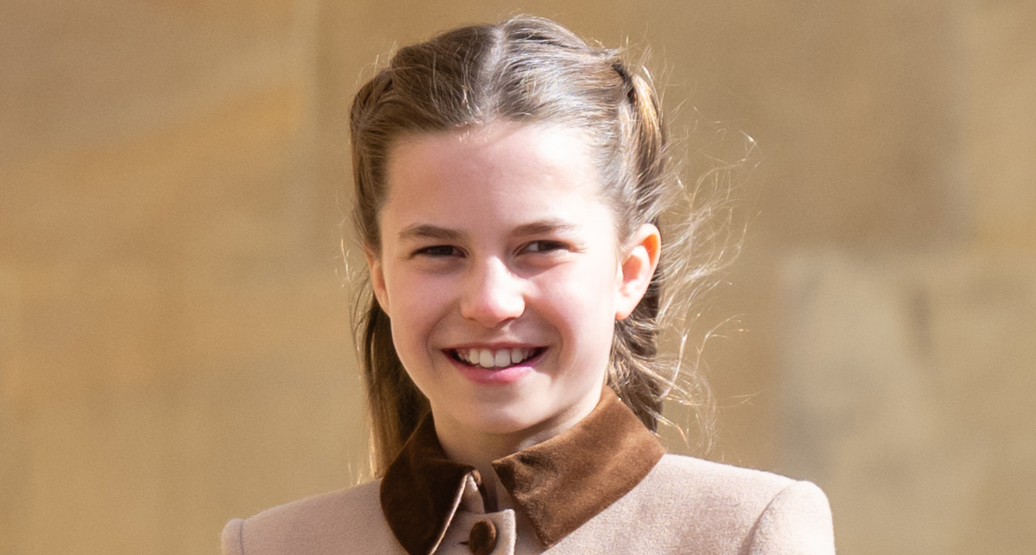 Princess Charlotte wearing a brown coat and smiling