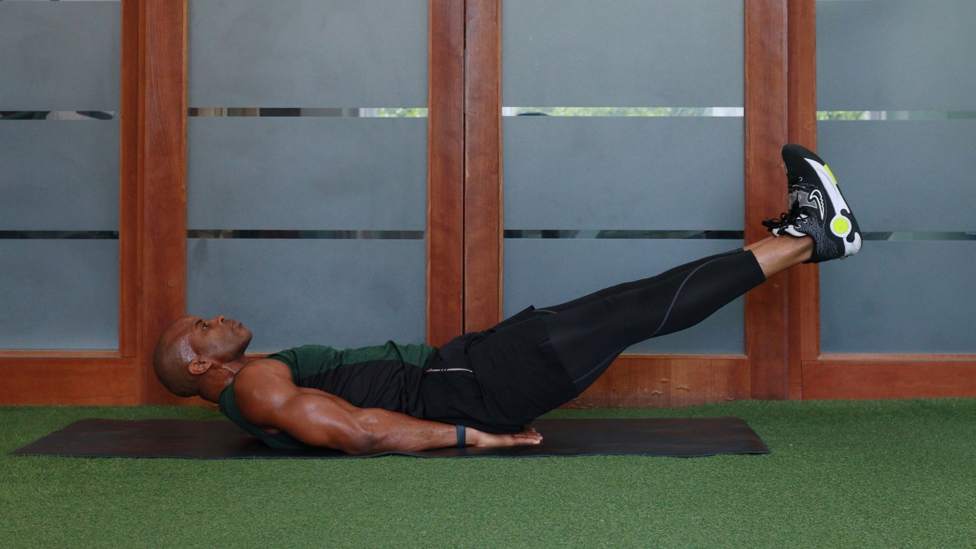 personal trainer on a yoga mat does ab exercise 