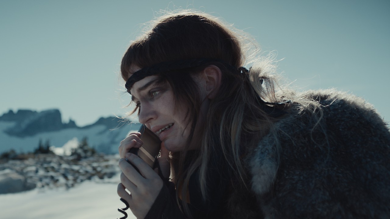 Nat on the phone at the top of a mountain in Yellowjackets Season 3.