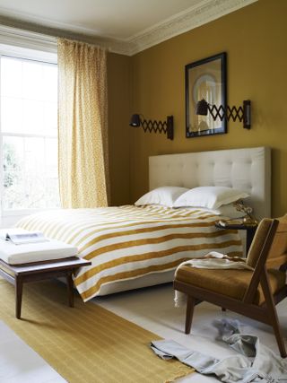 A mustard yellow themed bedroom with striped bedsheets