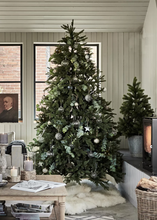 Christmas tree with silver tree decorations with fur tree skirt