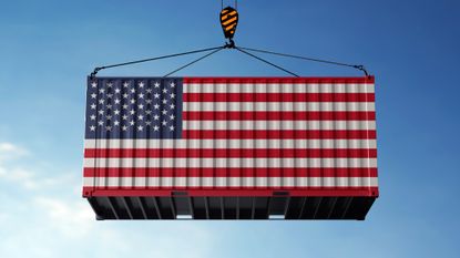 Trade cargo container with the American flag on it being lifted onto a ship 