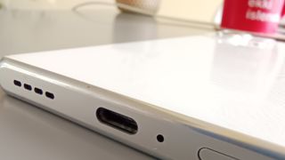 A white-backed Infinix Zero Ultra sitting on a table in front of a red coffee mug and a pot plant