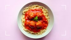 Bowl of spaghetti and meatballs on plain white china plate, representing the question of can menopause cause a loss of taste and smell