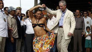 Britain's Prince Charles dances Caribo, an Amazonic traditional dance, with a local dancer during his visit to Maguari Community near Santarem, Para State, northern Brazil on March 14, 2009. Prince Charles is on a five-day official visit to Brazil, in which he visited Brasilia, Rio de Janeiro, Manaus and Santarem. AFP PHOTO/Evaristo SA