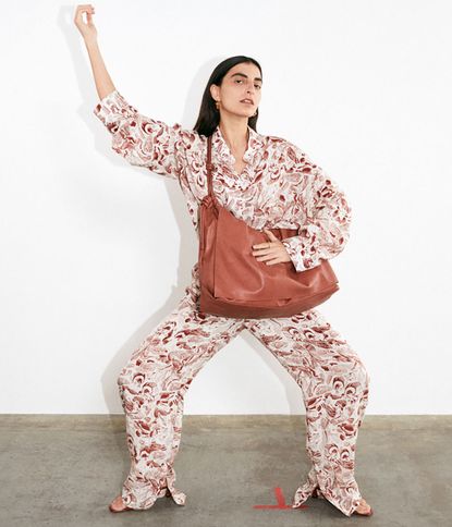 Model wears Aeron Pre-Fall 2021 floral shirt and trousers and tan jacket