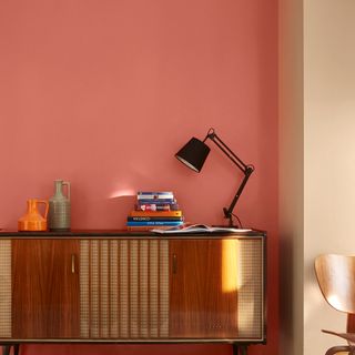 sideboard with lamp and pink wall