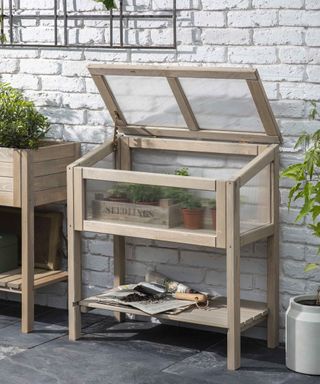 Cold frame on legs next to a white wall