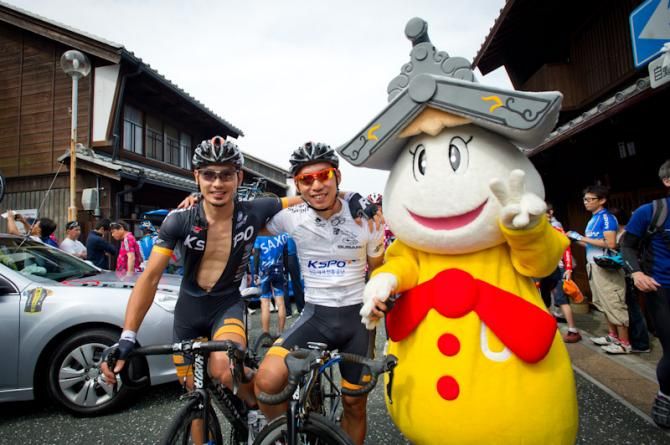Riders pose with the Tour of Japan mascot